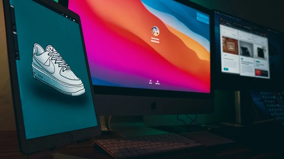 Un bureau lumineux avec un livre de design, un ordinateur portable et des outils créatifs, parfait pour stimuler l’inspiration.